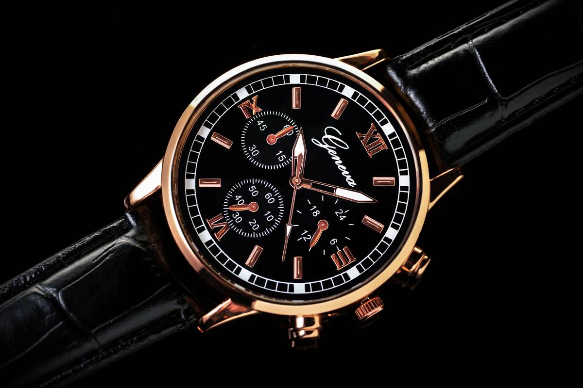 Close-up of commemorative watch colors on three limited-edition timepieces showing enamel dial, brushed steel bezel, and leather strap variations